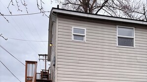 Une maison de plain-pied avec un escalier en bois menant à un petit porche.
