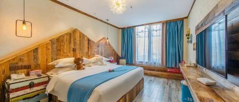 A bedroom with a sloped ceiling, a bed, a dresser, a window with curtains, and a television.
