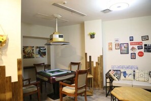A dining area with a table, chairs, and a hanging light fixture. - Shuiyue Qinghua Hotel (Deqing)