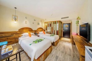 A hotel room with two beds, a wooden bench, a small table with amenities, and a TV. - Shuiyue Qinghua Hotel (Deqing)