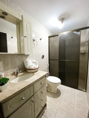 Un baño con lavamanos, inodoro y ducha.