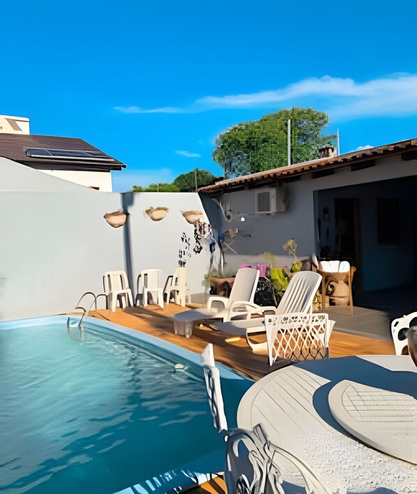 Una piscina con sillones de descanso y una zona de patio.