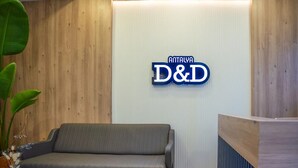 A reception area with a wooden wall, a grey sofa, and a reception desk. - Antalya D&D Terrace (Antalya)