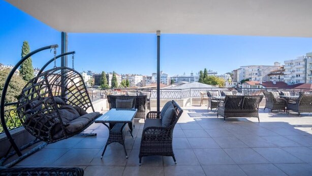 An outdoor terrace with wicker furniture, a table, and a hanging chair. - Antalya D&D Terrace (Antalya)