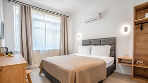 A modern hotel room with a large bed, a wooden desk, and a built-in wardrobe. - Antalya D&D Terrace (Antalya)