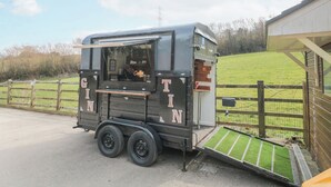 A mobile coffee truck with a small window and a ramp for accessibility.
