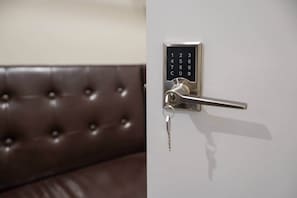 A modern door with a numeric keypad lock and a key inserted.