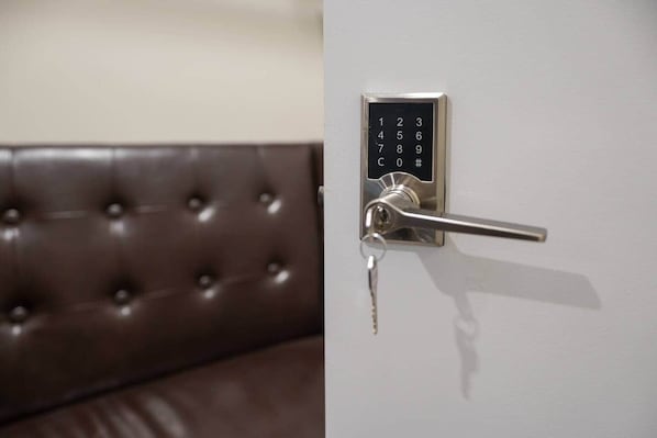 A modern door with a numeric keypad lock and a key inserted.