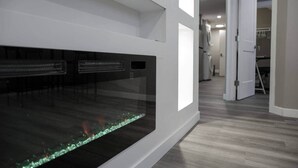A modern interior with a large aquarium, a hallway with a door, and a visible laundry area.