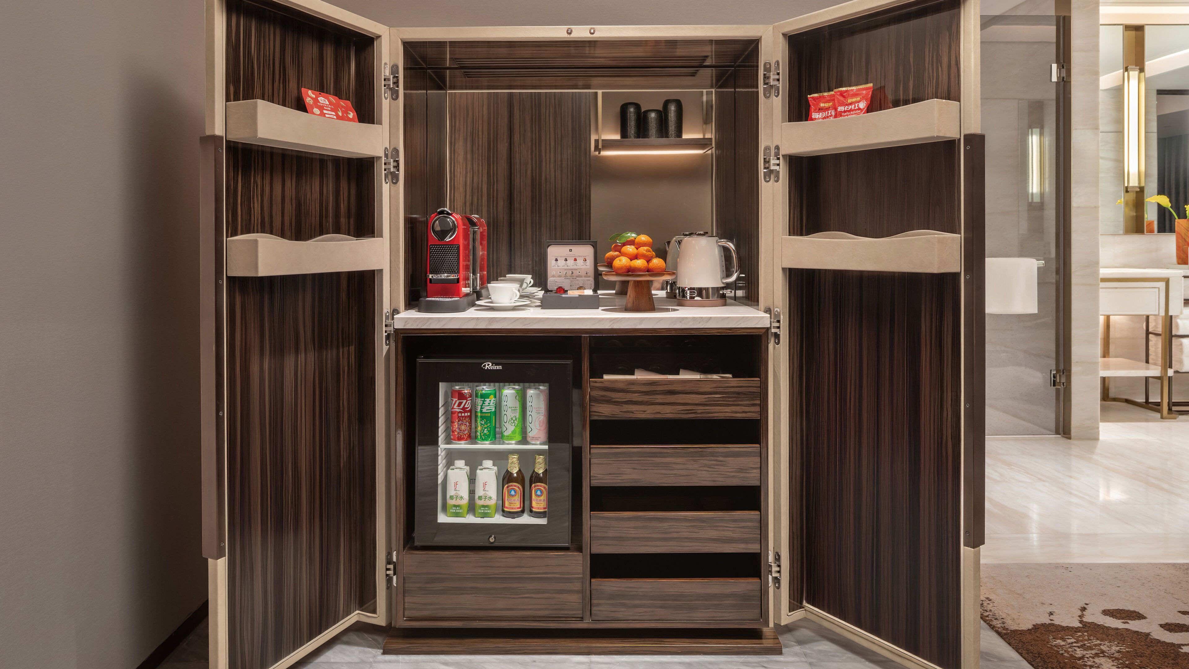 A compact minibar with a refrigerator, a coffee machine, and a small selection of beverages.