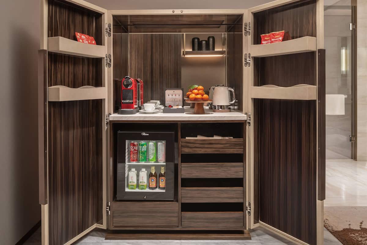 A compact minibar with a refrigerator, a coffee machine, and a small selection of beverages.