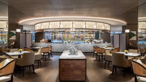 A modern restaurant interior with a central bar, seating area, and a decorative centerpiece. - InterContinental Zhengzhou Zhengdong by IHG (Zhengzhou)