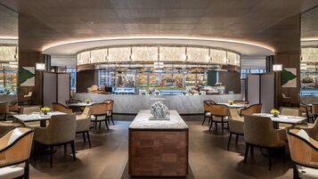 Un restaurante moderno con barra central, zona de estar y un elemento decorativo principal.