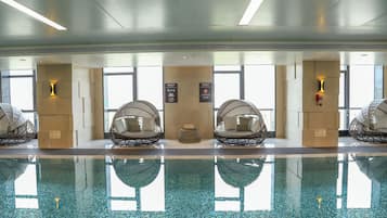 Una piscina techada, abierta desde las 06:00 hasta las 23:00, sombrillas