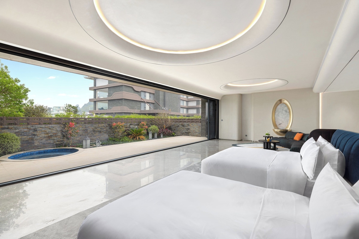A modern interior with a large window, a pool, and a sofa.