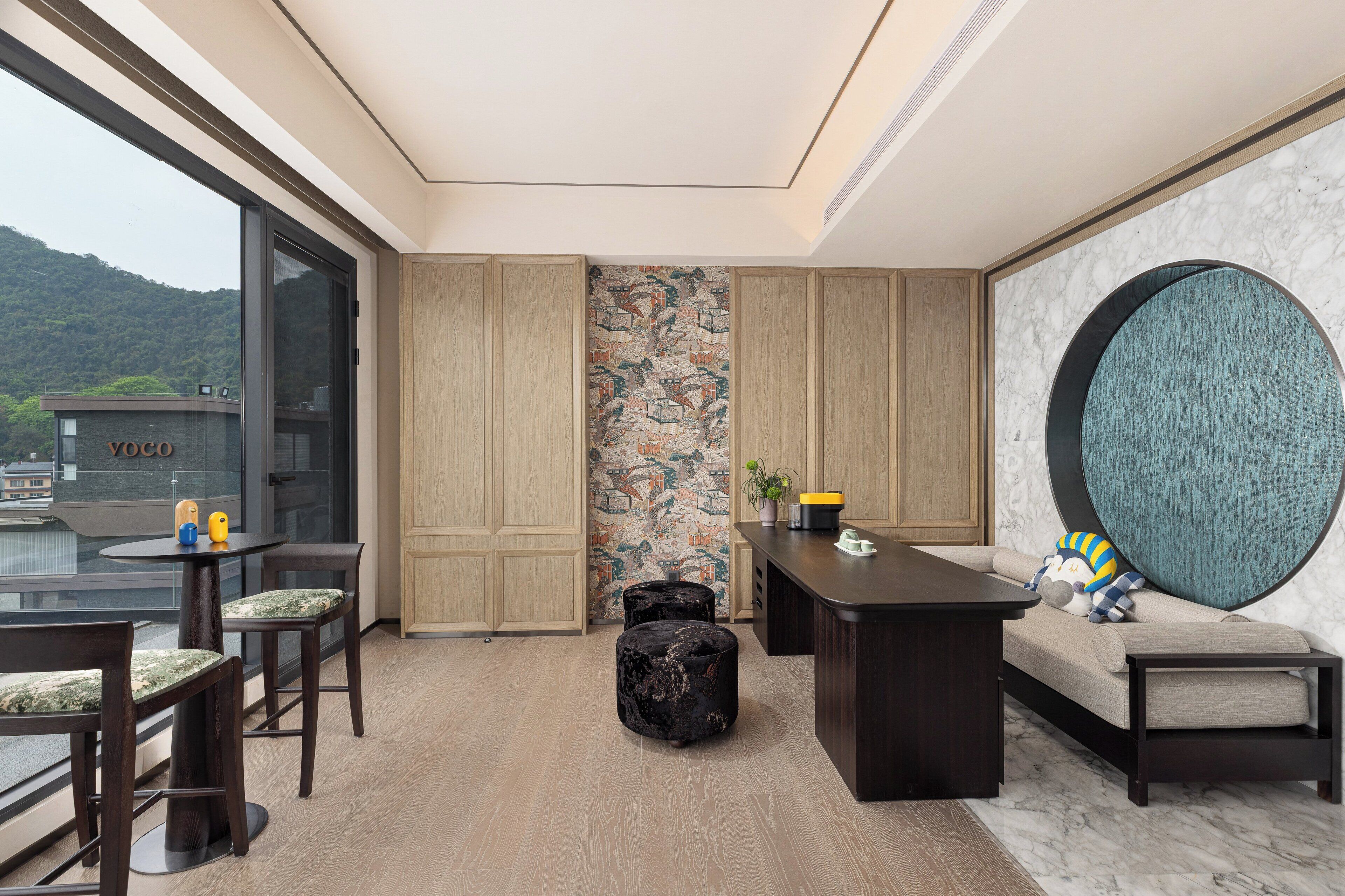 A modern interior with a dining area, seating, and a view of a mountain.