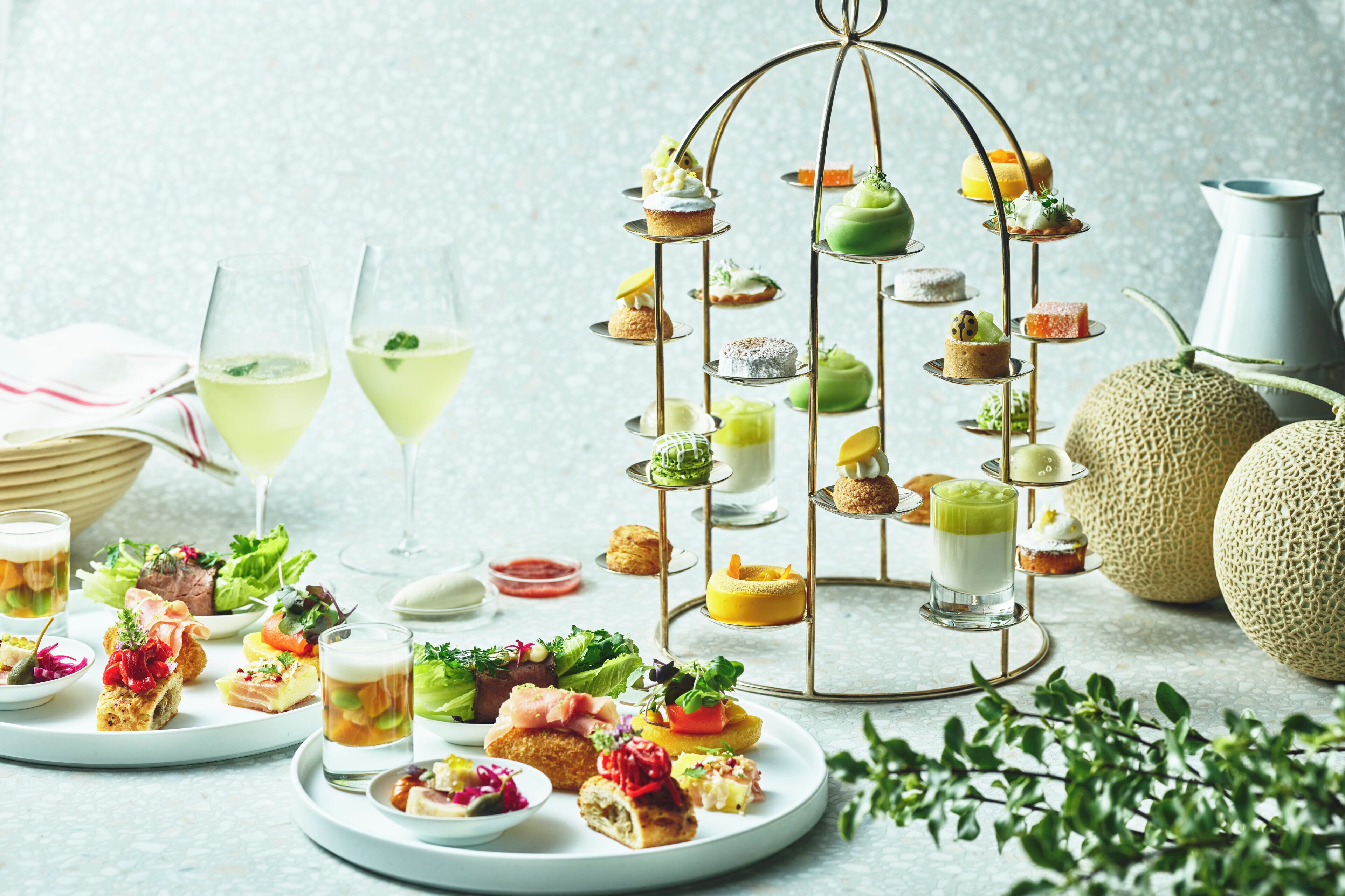 Diverse gerechten en drankjes op borden en een etagère met desserts.