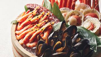 A variety of seafood including shrimp, mussels, and scallops arranged on a wooden platter.