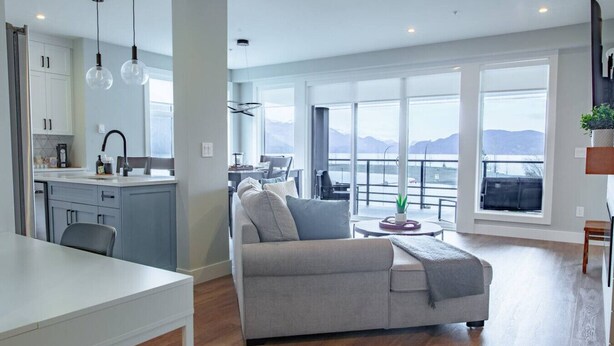 Un espacio habitable moderno con cocina, comedor y un amplio ventanal con vistas panorámicas.