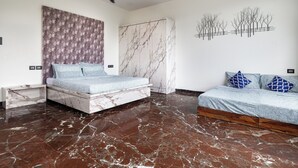 Une chambre à coucher avec un lit, une table de chevet, un ventilateur de plafond et un sol en marbre.