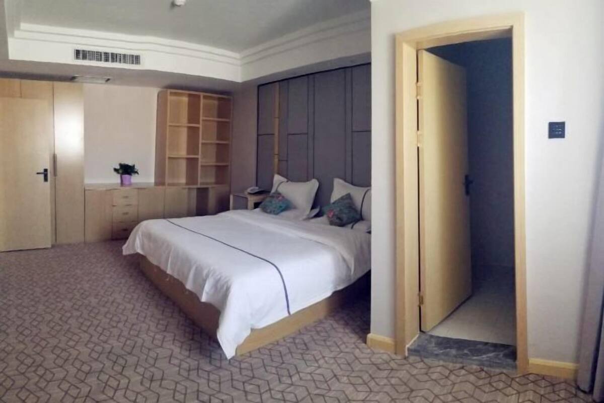 Ein Schlafzimmer mit einem Bett, einem Kleiderschrank und einer eingebauten Schrankwand.