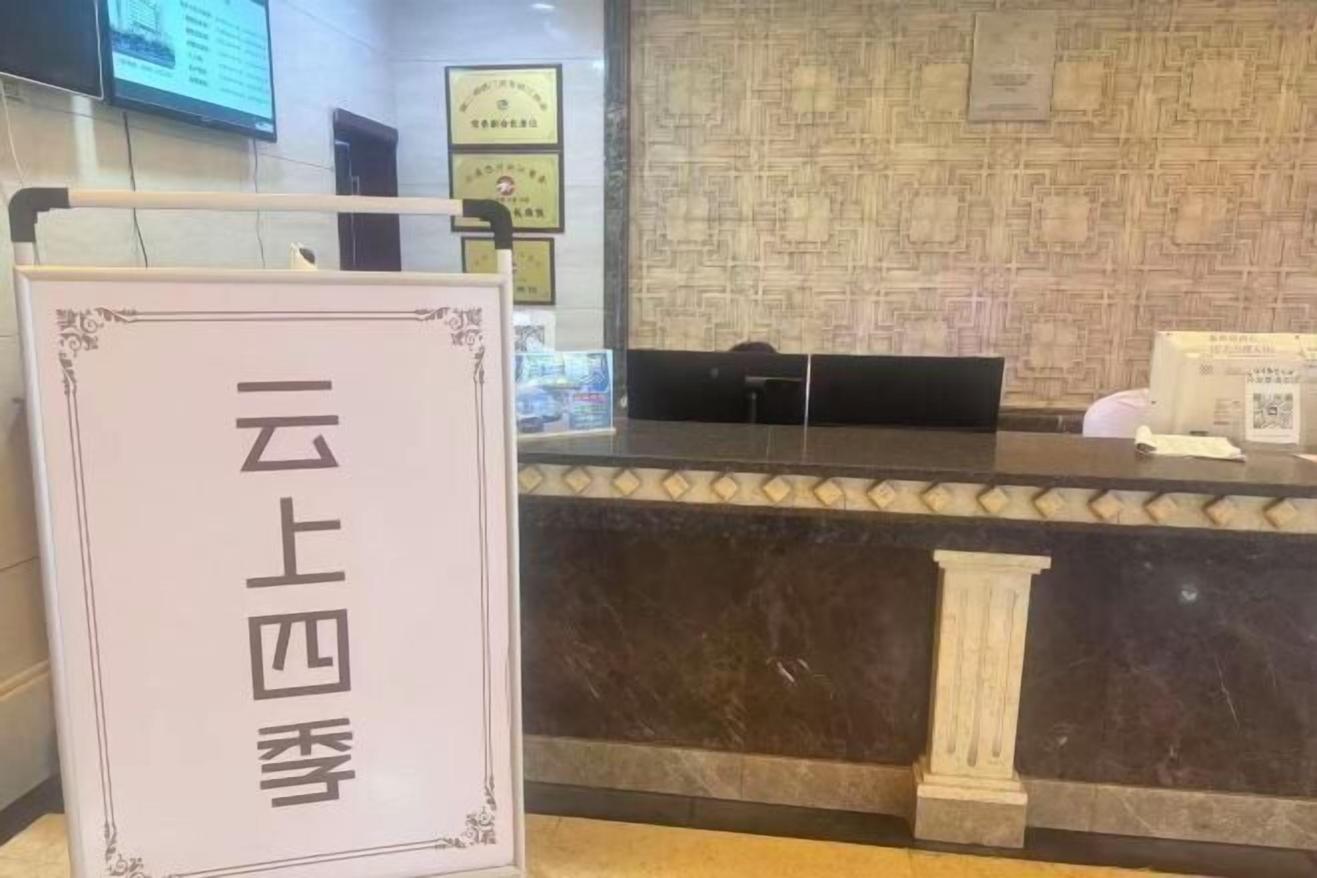 A reception desk with a marble counter and a sign with Chinese characters.