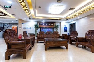 A lobby with wooden furniture, a reception desk, and a sign with Chinese characters.