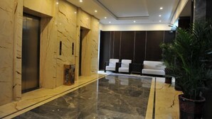 A modern lobby with marble flooring, a reception desk, and seating area. - Hua Xin Hotel Hengyang (Hengyang)