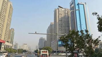 A city street with tall buildings, vehicles, and streetlights.