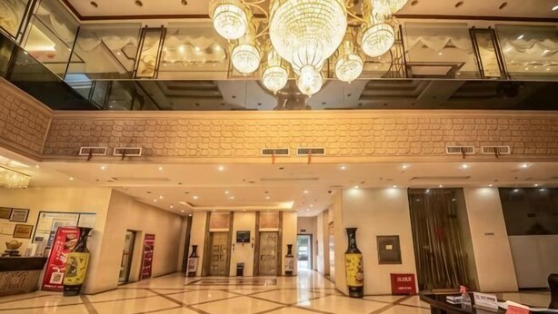 A hotel lobby with a chandelier, a reception desk, and a check-in counter. - Hua Xin Hotel Hengyang (Hengyang)