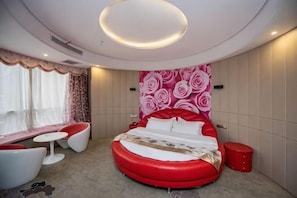 A modern bedroom with a circular bed, a seating area, and a large window. - Hua Xin Hotel Hengyang (Hengyang)