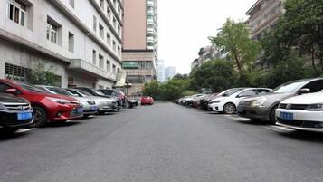 A row of parked cars along a street with buildings on either side.