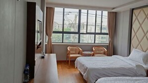 Ein Hotelzimmer mit einem Bett, einem Schreibtisch, einem Stuhl und einem großen Fenster.