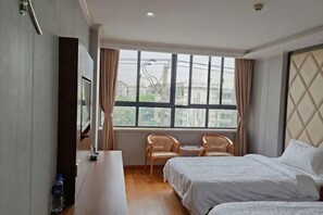 Une chambre d’hôtel avec un lit, un bureau, une chaise et une grande fenêtre.