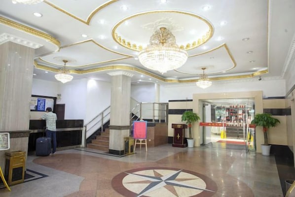 A hotel lobby with a reception desk, a staircase, and a large chandelier. - Yun Hai Hotel (Shanghai)