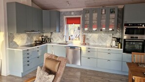 A modern kitchen with grey cabinets, a built-in oven, and a dishwasher.