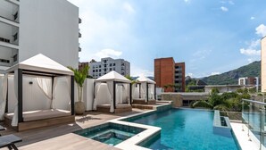 A rooftop pool area with multiple seating areas and a clear view of the surrounding buildings. - RM 210 | Beauty, Balcony, Elevator, Security, Pool (Cali)