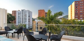 Una terraza en la azotea con mobiliario exterior y vistas de los edificios circundantes.