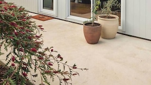 A modern building with a white exterior, large sliding glass doors, and potted plants on the patio. - Welcome to Birch BnB (Newstead)