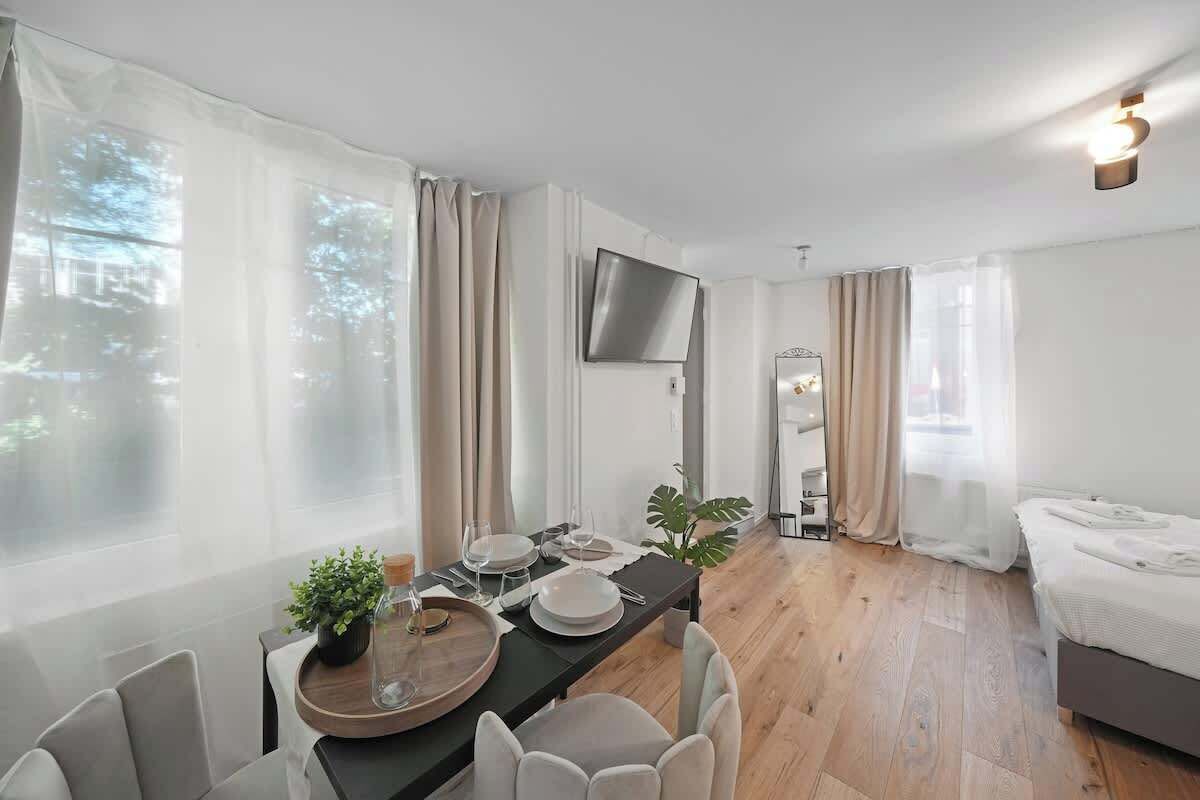 Une chambre d’hôtel moderne équipée d’un coin repas, d’un lit et d’une télévision.