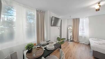 Une chambre d’hôtel moderne équipée d’un coin repas, d’un lit et d’une télévision.