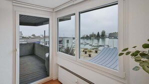 A balcony with a view of a marina and buildings. - book2stay: Lakefront Apt w/Balcony, near Harbor & Station (Romanshorn)