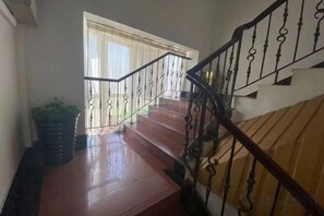 A staircase with a metal railing leading to a room with a window. - Jujia Hostel (Shanghai)
