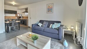 Una sala moderna con un sofá, una mesa de centro y un comedor con sillas y una mesa.