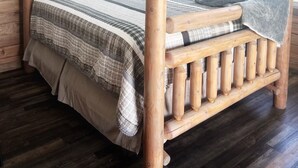A wooden bed with a headboard, a ceiling fan, and a framed picture on the wall.
