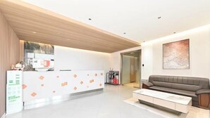 A modern lobby with a reception desk, a sofa, and a coffee table. - Youyue Selected Hotel (Beijing South Station Temple of Heaven South Gate Branch) (Beijing)