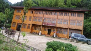 A multi-story building with a traditional architectural style, featuring a flat roof and a symmetrical facade. - Chiyou Valley Homestay (Xinhua)