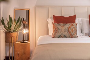 Cozy retreat with a large bed, nightstand, and full-length mirror.