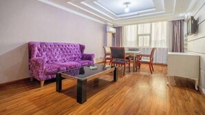 A room with a purple sofa, a glass coffee table, wooden flooring, a dining area with chairs, and a ceiling with skylights. - Tuk China Light Residence Hotel (Taizhou Luqiao Airport Branch) (Taizhou)
