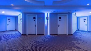 A hotel hallway with a patterned carpet, white doors, and recessed lighting. - Tuk China Light Residence Hotel (Taizhou Luqiao Airport Branch) (Taizhou)